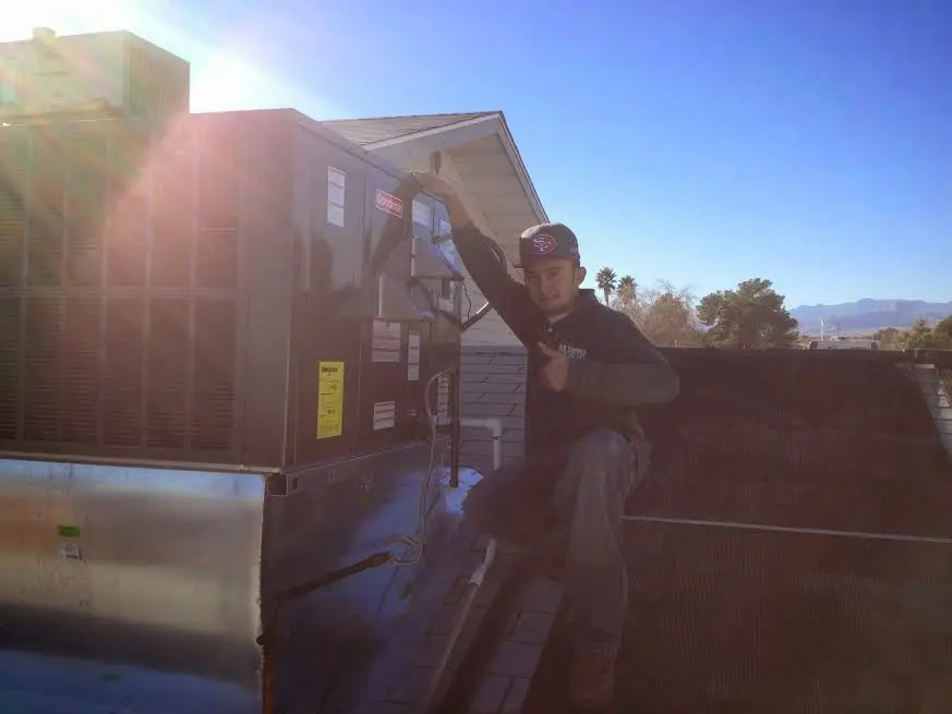 HVAC technician performing Boiler Repair on a rooftop unit in Rome